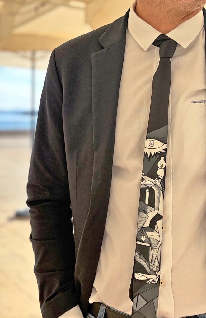 Corbata pintada a mano inspirada en el Guernica de Picasso, en blanco y negro, lucida con traje